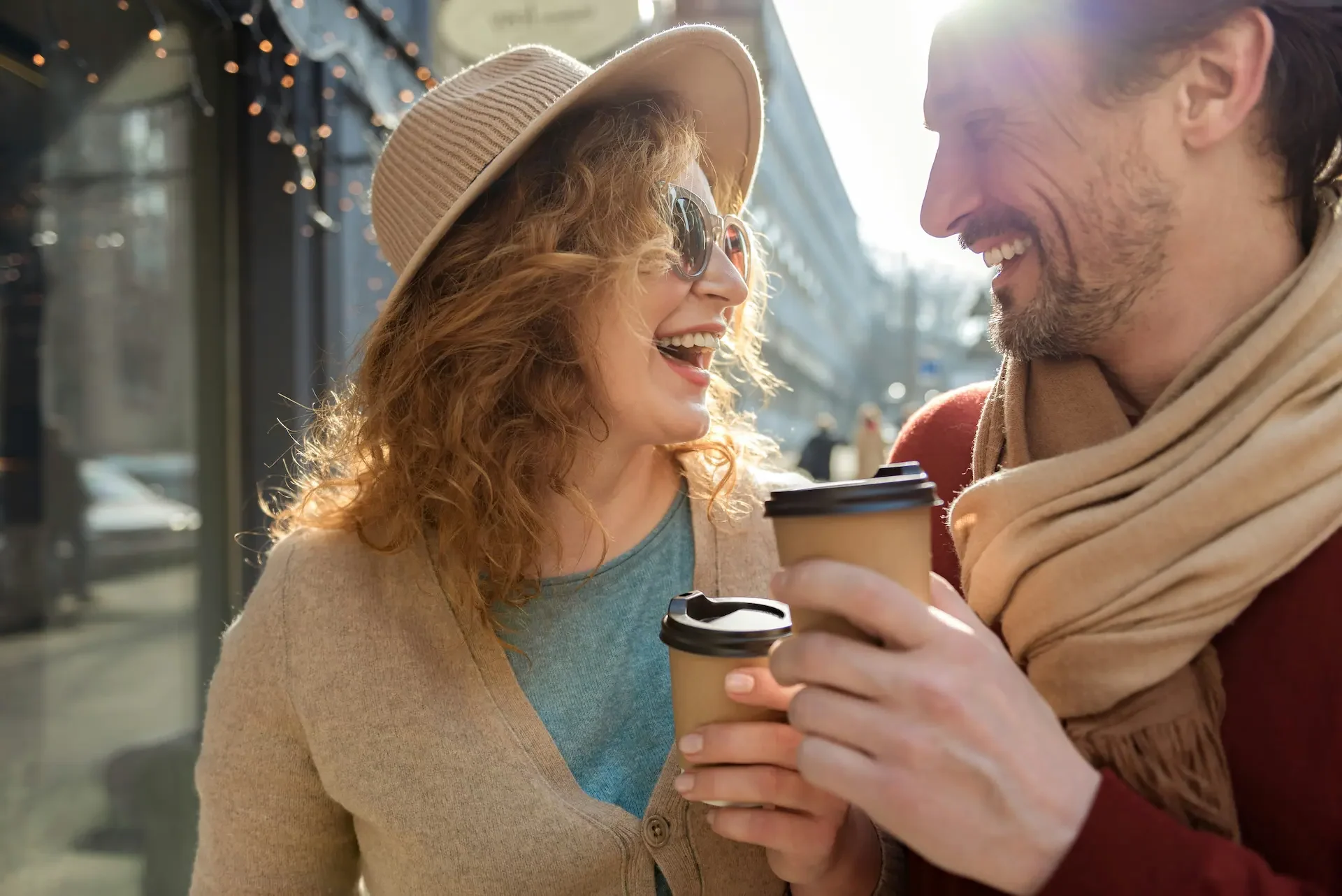 Friends walking outside shops drinking coffee and enjoying cool weather.