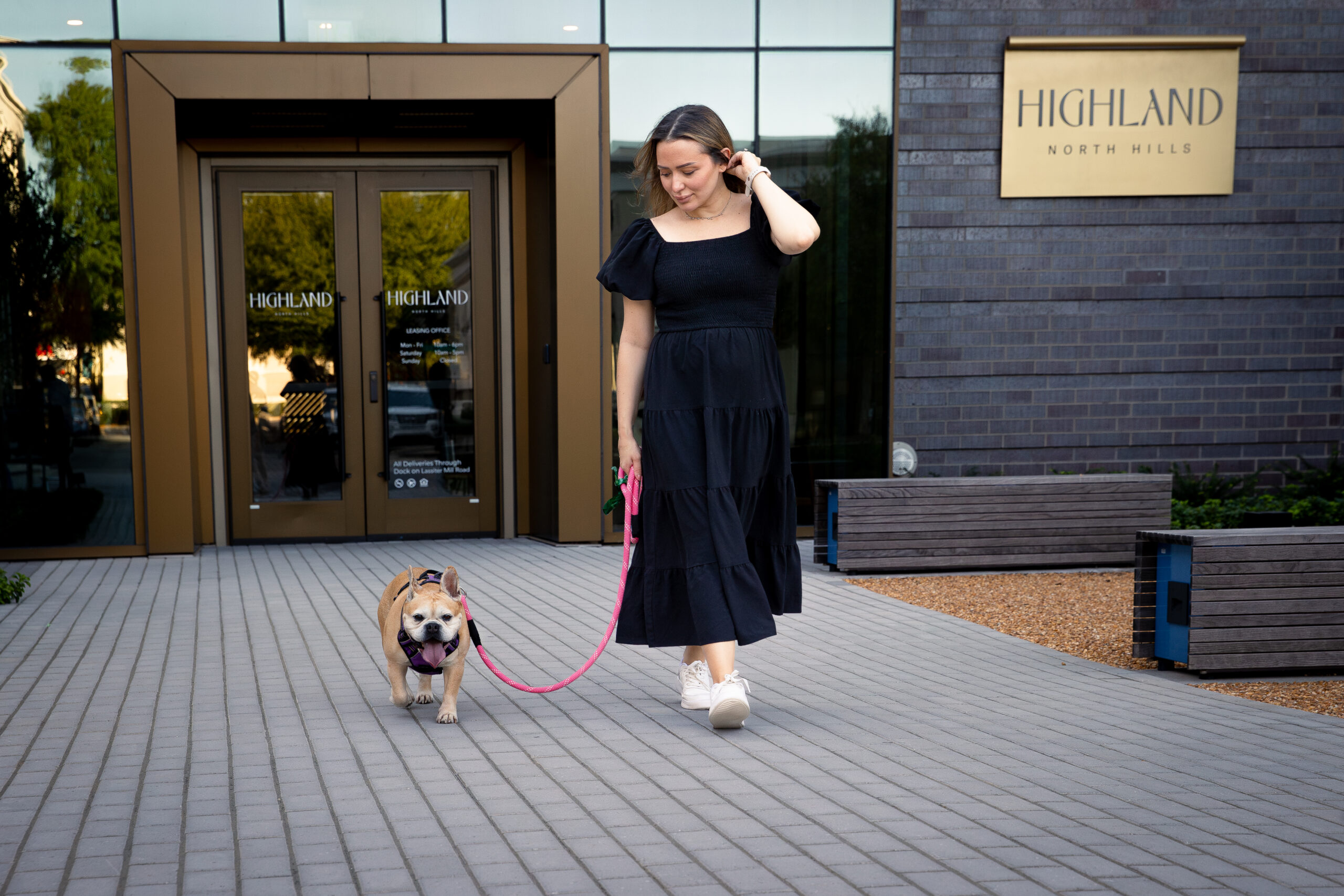 Woman walking her dog in front of Highland apartments